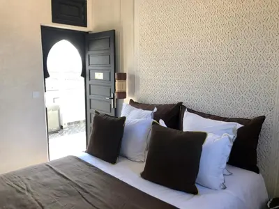 a bed with black and white pillows in a bedroom at Riad Dar Bahi in Marrakech