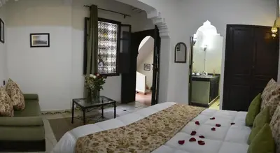 a bedroom with a bed and a living room at Dar Asdika in Marrakech