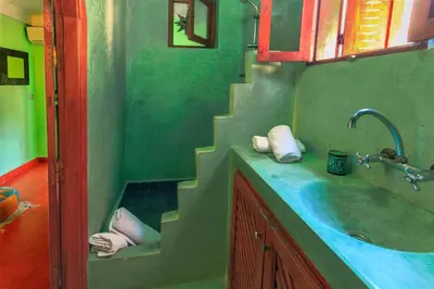 a green bathroom with a sink and a staircase at Riad Zen House in Marrakech
