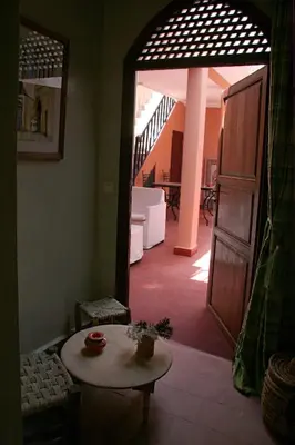 a room with a table and a hallway with a staircase at Riad Zen House in Marrakech
