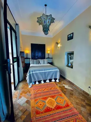 a bedroom with a bed with a rug in it at Riad El Youssoufi in Marrakech