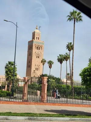a clock tower with palm trees in front of a fence at Silia in Marrakech