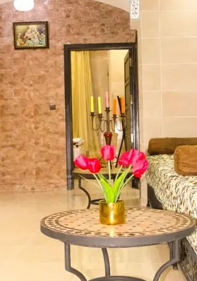 a table with red flowers on it in a room at Silia in Marrakech