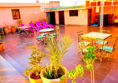 a patio with tables and chairs and potted plants at Silia in Marrakech