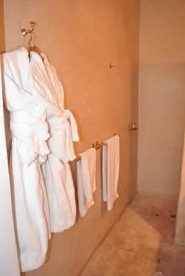 a bathroom with white towels hanging on a wall at Riad Essaada in Marrakech