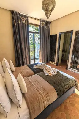 a large bed in a bedroom with a large window at Villa 69 Samanah Golf Country Club in Ala el Ma