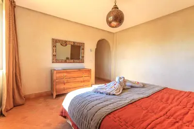 a bedroom with a bed and a dresser and a mirror at Villa 69 Samanah Golf Country Club in Ala el Ma