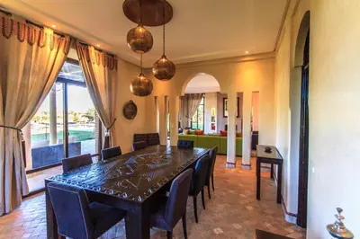 a dining room with a table and chairs at Villa 69 Samanah Golf Country Club in Ala el Ma