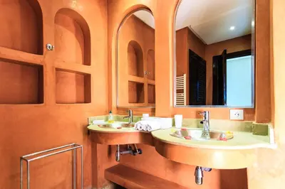 a bathroom with two sinks and a mirror at Villa 69 Samanah Golf Country Club in Ala el Ma