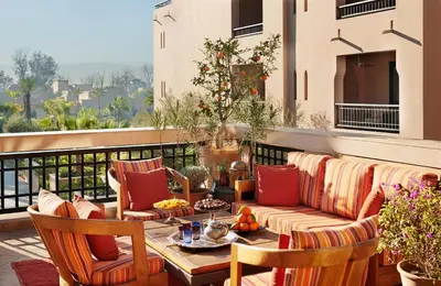 a patio with a table and chairs on a balcony at Four Seasons Resort Marrakech in Marrakech
