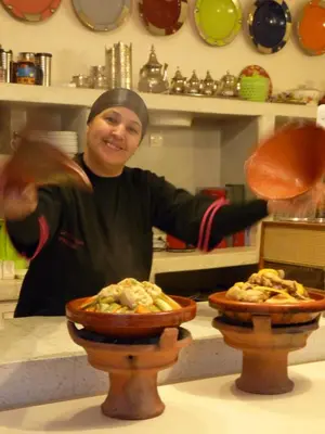 a woman standing in a kitchen with a plate of food at Riad Noos Noos & Spa in Marrakech
