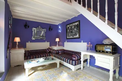 a living room with purple walls and a couch at Riad Noos Noos & Spa in Marrakech