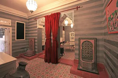 a living room with a red curtain and a table at Riad Noos Noos & Spa in Marrakech