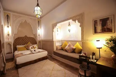 a bedroom with two beds and a chandelier at Riad Melhoun & Spa in Marrakech