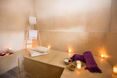 a room with a table with purple blankets and candles at Riad Dar 73 in Marrakech