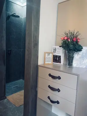 a bathroom with a dresser with a vase of red roses at Riad Dar 73 in Marrakech