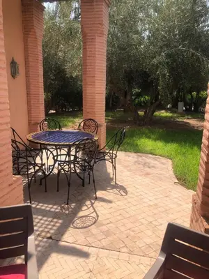 a table and chairs on a brick patio at la palmeraie village Appartement in Marrakech