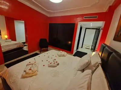 a bedroom with a large bed with red walls at Elegant Gueliz Retreat near Majorelle in Marrakech