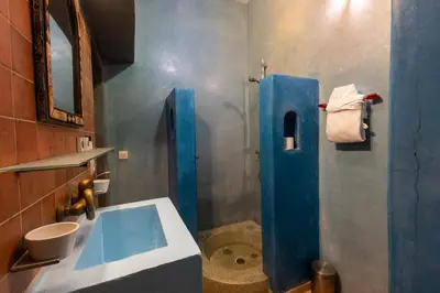 a bathroom with a blue sink and a toilet at Riad Aicha Marrakech in Marrakech