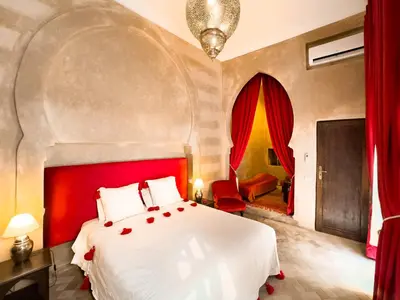 a bedroom with a large bed with a red headboard at Riad Selouane in Marrakech