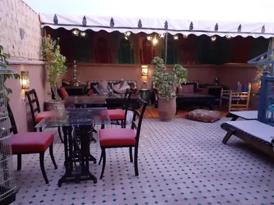 a dining room with a glass table and chairs at Riad Simon in Marrakech