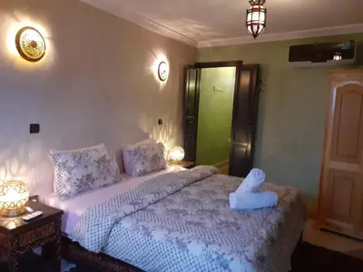 a bedroom with a bed with a stuffed animal on it at Riad Simon in Marrakech