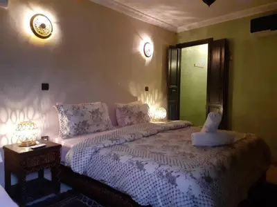 a bedroom with a large bed with two lamps on it at Riad Simon in Marrakech