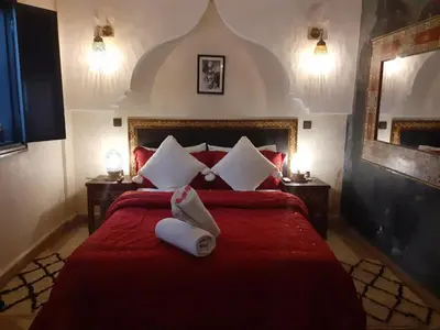 a bedroom with a red bed with two towels on it at Riad Simon in Marrakech
