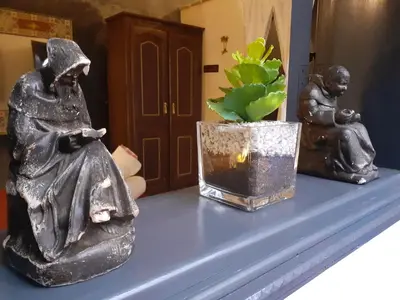 two statues sitting on a shelf with a potted plant at Riad Simon in Marrakech