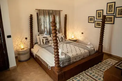 a bedroom with a four poster bed and two lamps at Riad les Ammonites and Spa in Marrakech