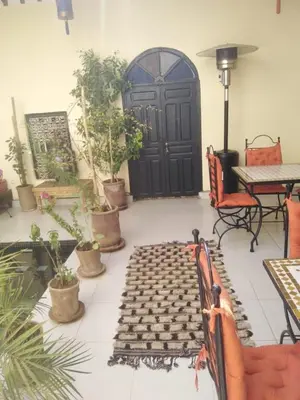 a patio with a black door and potted plants at Riad JEREMY in Marrakech