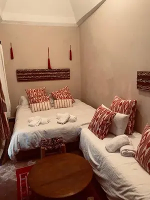 a room with two beds and a table in it at RIAD DES DEUX MERS in Marrakech