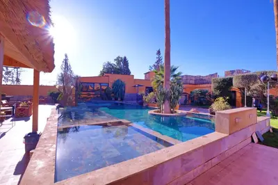 a swimming pool in a yard with a house at Hacienda Marrakech in Marrakech