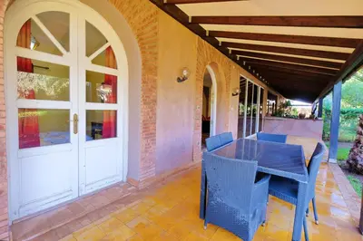 a patio with a table and chairs on a porch at Hacienda Marrakech in Marrakech