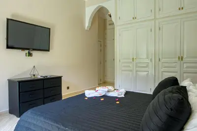 a bedroom with a bed and a flat screen tv at Villas 95 Appart'Hôtel in Marrakech