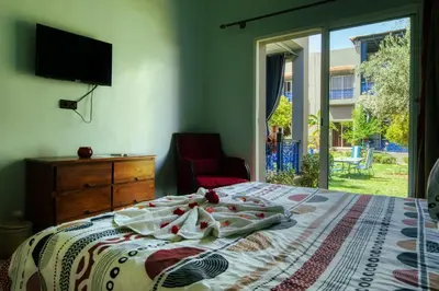 a bedroom with a bed and a tv and a window at Villas 95 Appart'Hôtel in Marrakech