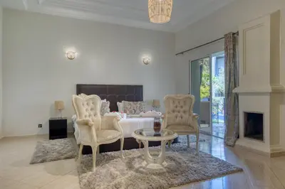 a bedroom with a bed and a table and chairs at Villas 95 Appart'Hôtel in Marrakech