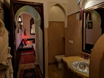 a bathroom with a toilet and a sink with a mirror at Riad Charme d'Orient Adults Only in Marrakech