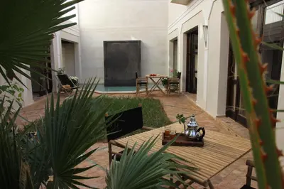 a patio with a table and a blackboard in a house at Riad Spa Dar Nimbus in Marrakech