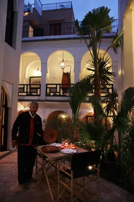 a man standing next to a table in a building at Riad Spa Dar Nimbus in Marrakech