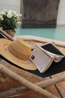 a straw hat and a book sitting on a table at Riad Spa Dar Nimbus in Marrakech