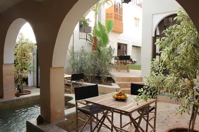 an outdoor patio with a table with fruit on it at Riad Spa Dar Nimbus in Marrakech