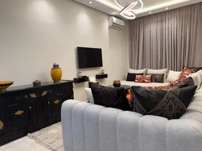 a living room with a couch and a flat screen tv at Caprice Palace in Marrakech