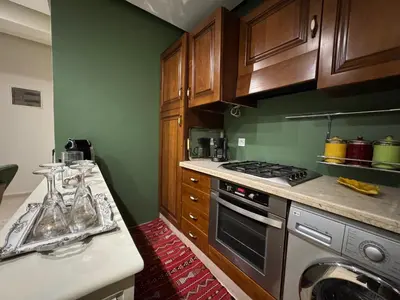 a kitchen with wooden cabinets and a stove top oven at Caprice Palace in Marrakech