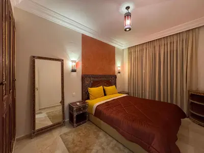 a bedroom with a large bed and a mirror at Caprice Palace in Marrakech