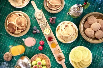 a table with plates of food and bowls of food at Riad Dar Amanza en exclusivité avec 4 chambres au coeur de la médina in Marrakech