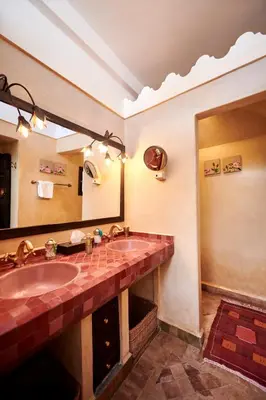 a bathroom with a sink and a large mirror at Riad Dar Amanza en exclusivité avec 4 chambres au coeur de la médina in Marrakech