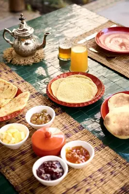 a table with plates of food and a teapot at Riad Dar Amanza en exclusivité avec 4 chambres au coeur de la médina in Marrakech