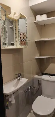 a bathroom with a toilet and a sink and a mirror at Appart Piscine Jardin somptueux à 2 min de palmeraie et 10 min de Majorelle in Marrakech