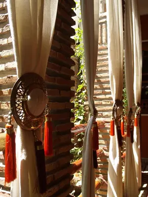 a group of curtains hanging on a brick wall at Riad Laith in Marrakech